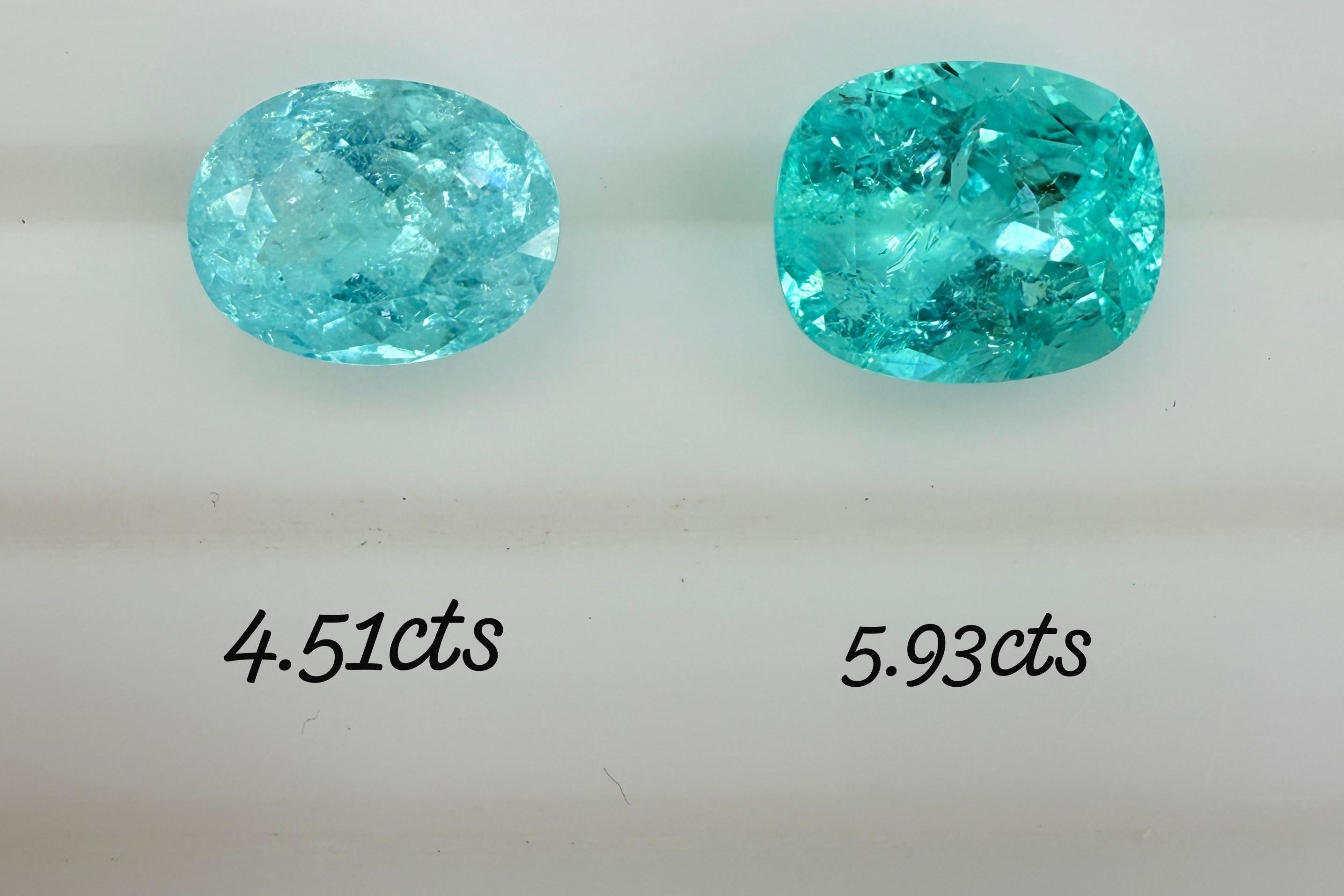 Two oval-cut turquoise gemstones displayed side by side on a white background, with weight labels underneath reading 4.51cts, 5.93cts